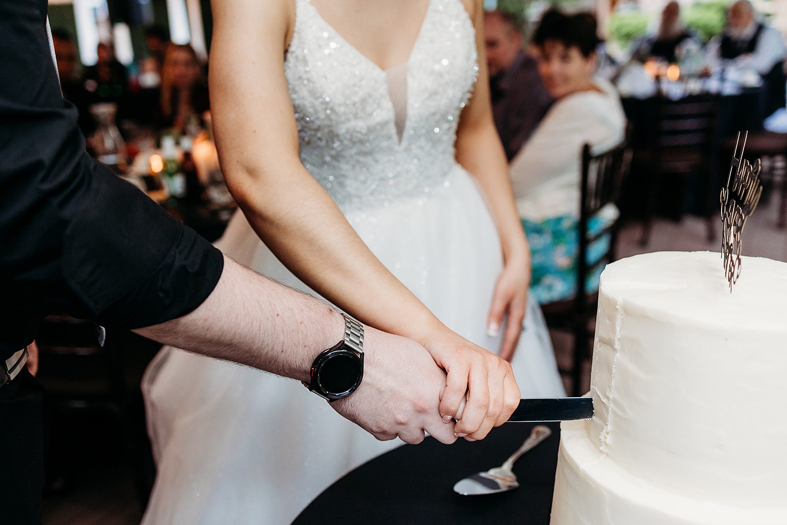 Details of a bride and groom cutting their cake together