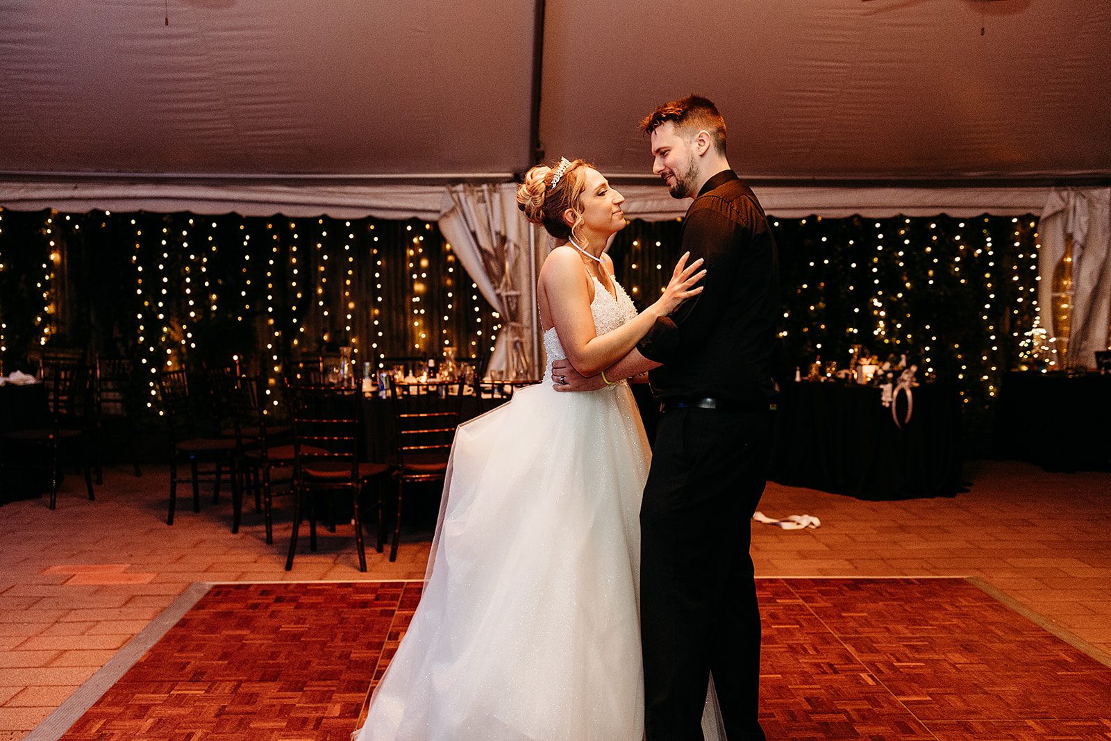 Newlyweds share a happy smile while dancing alone in an empty dance floor under a tent at their The Inn At Saratoga Wedding