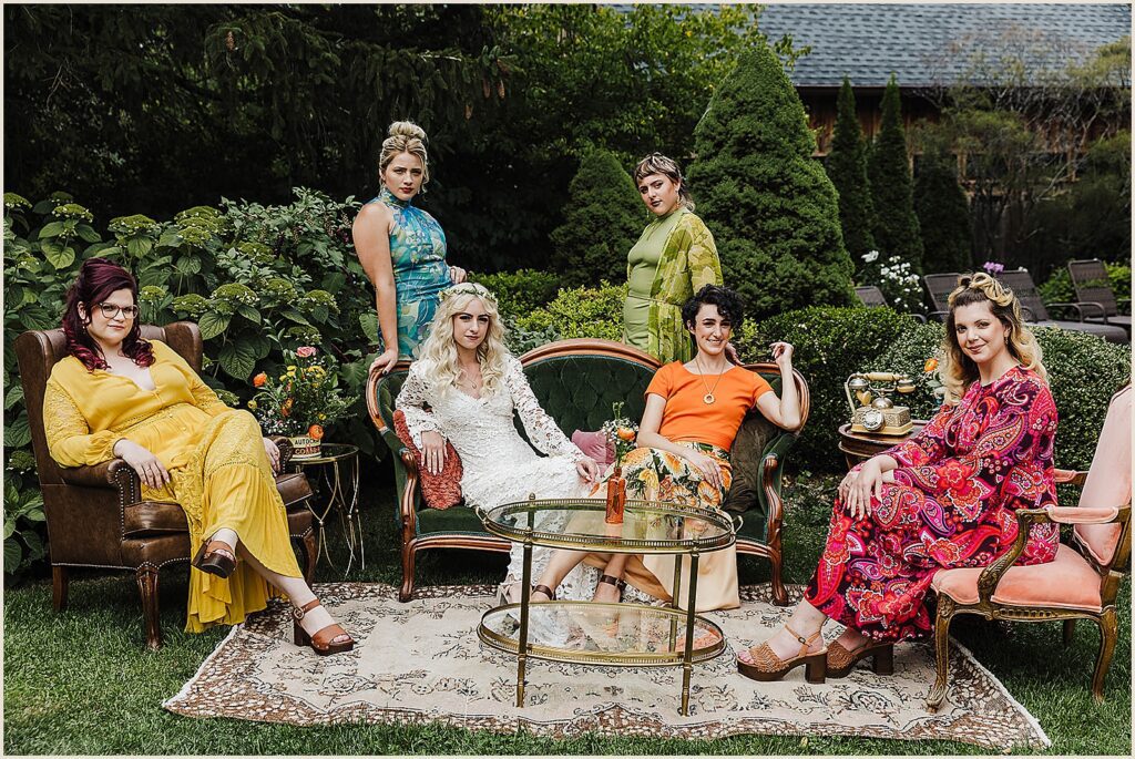 A bride poses with bridesmaids in colorful dresses.