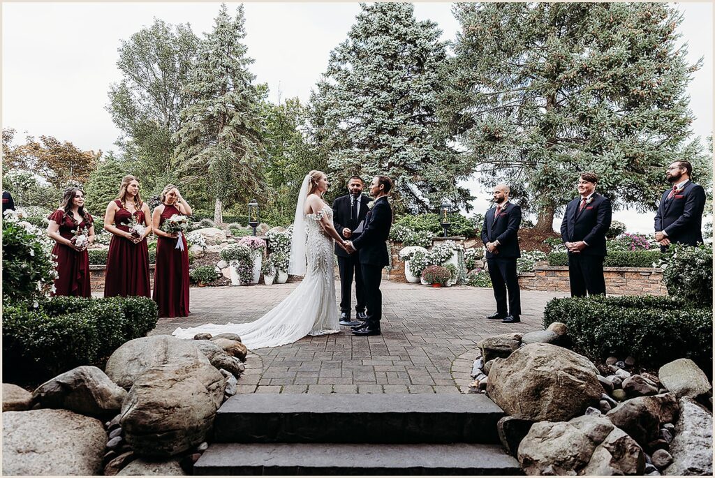 A bride and groom hold hands during a wedding at a New York wedding venue.