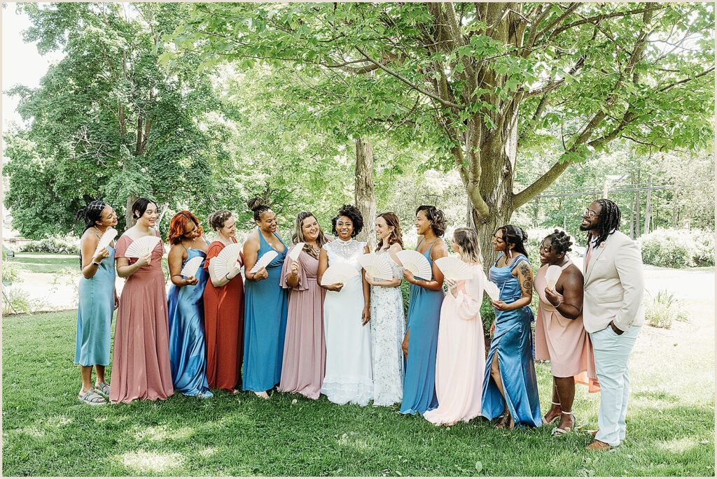 A bride stands in the center of a line of bridesmaids.