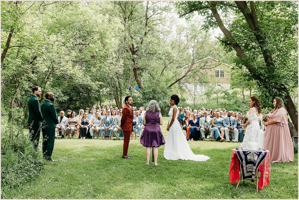 A bride and groom stand in front of their wedding guests at The Maples Estate.