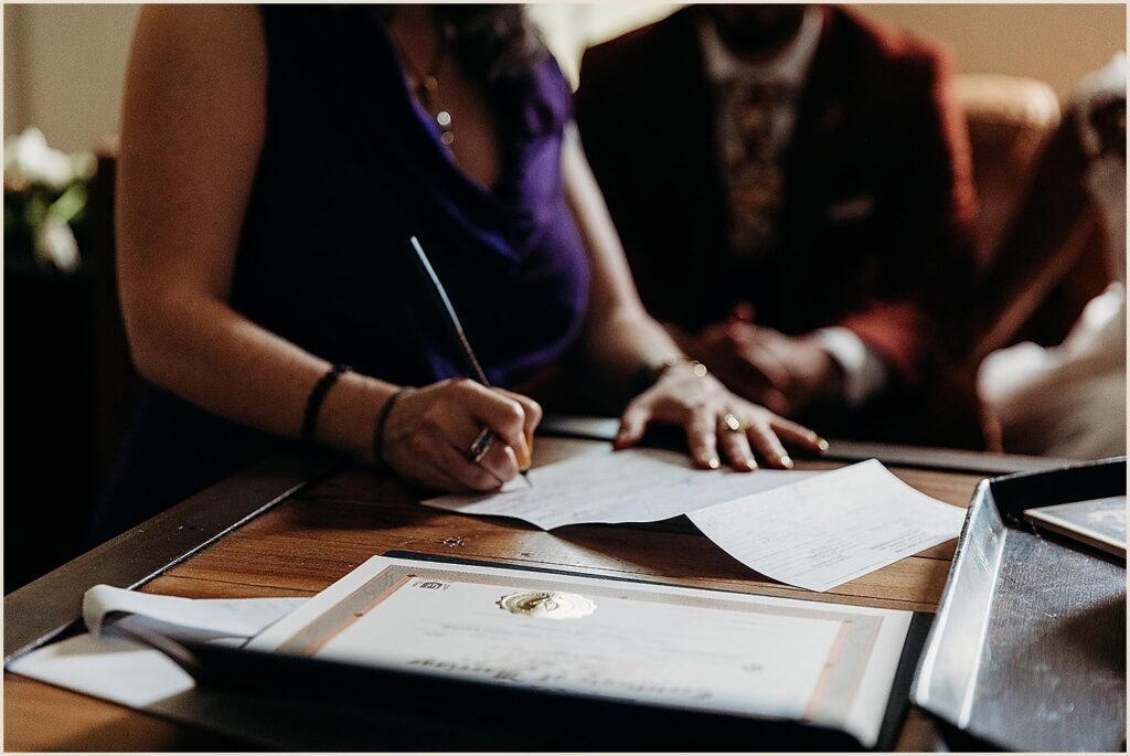A woman signs a marriage license.