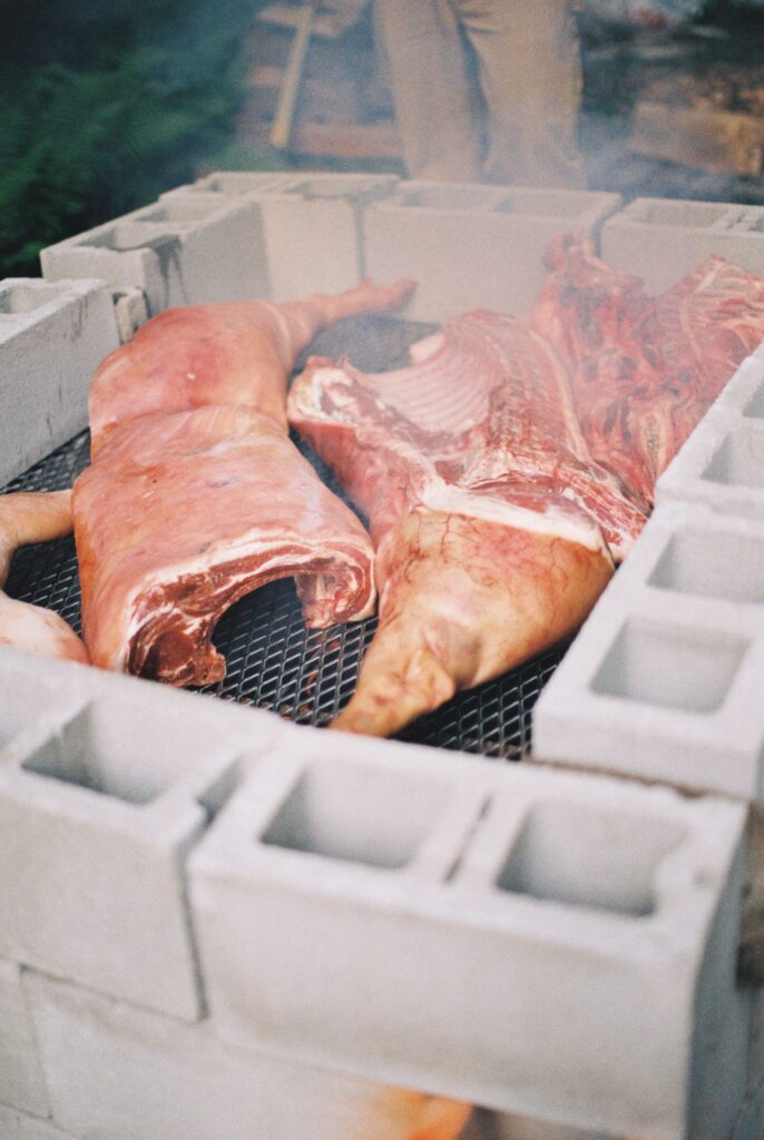 A pig roasts in a pit.