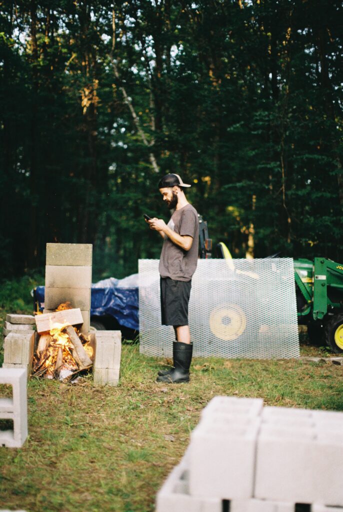 A man oversees a roasting pit.