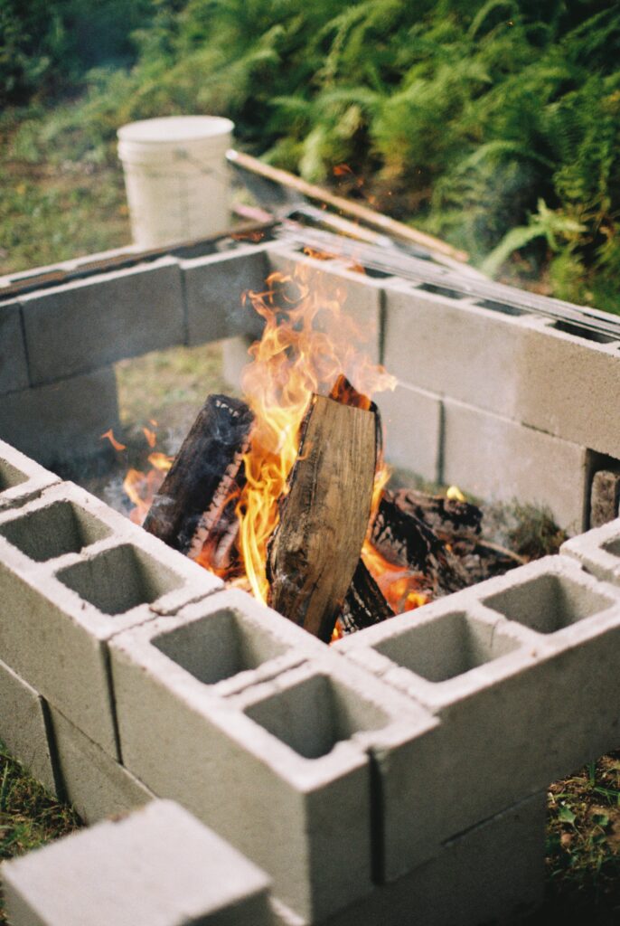 A fire flares in a roasting pit on a film wedding photo.