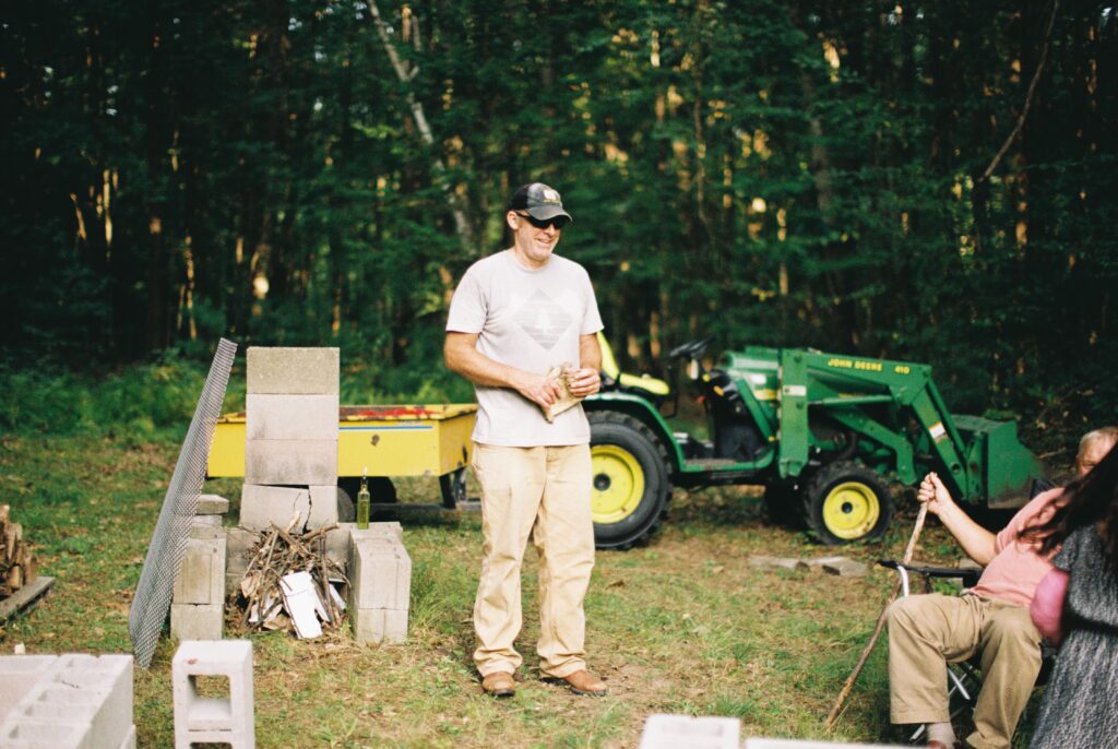 A person stands beside a tractor.