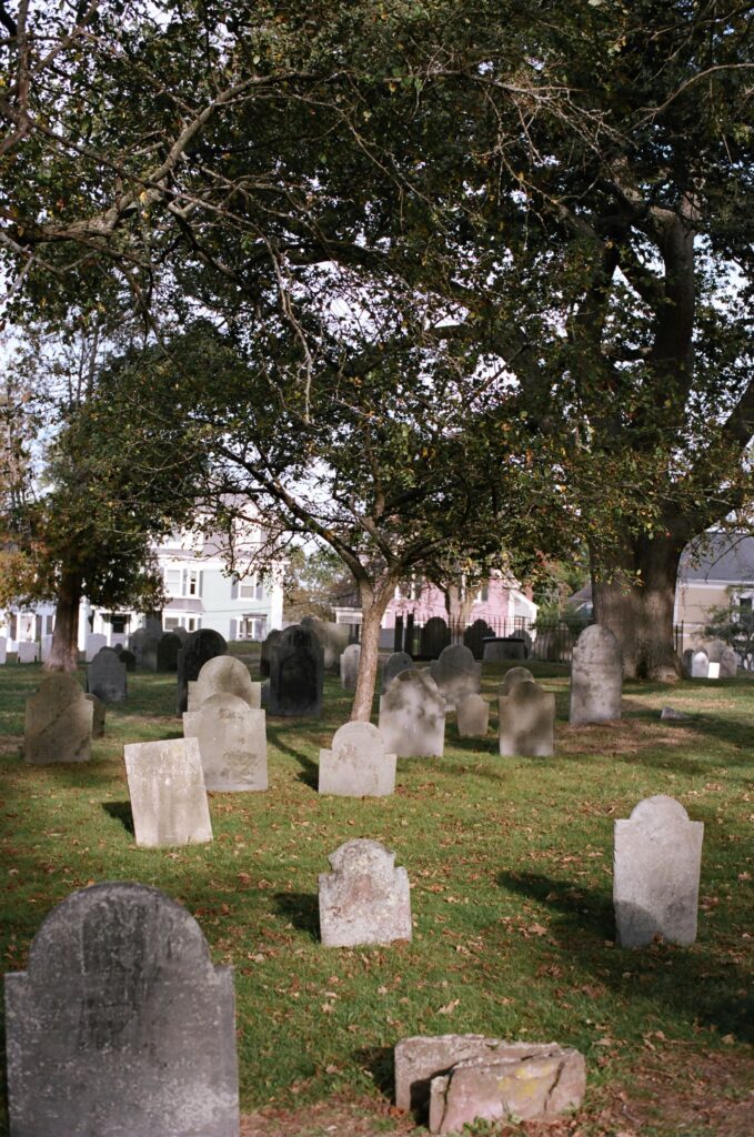 Gravestones cast shadows in film photography.