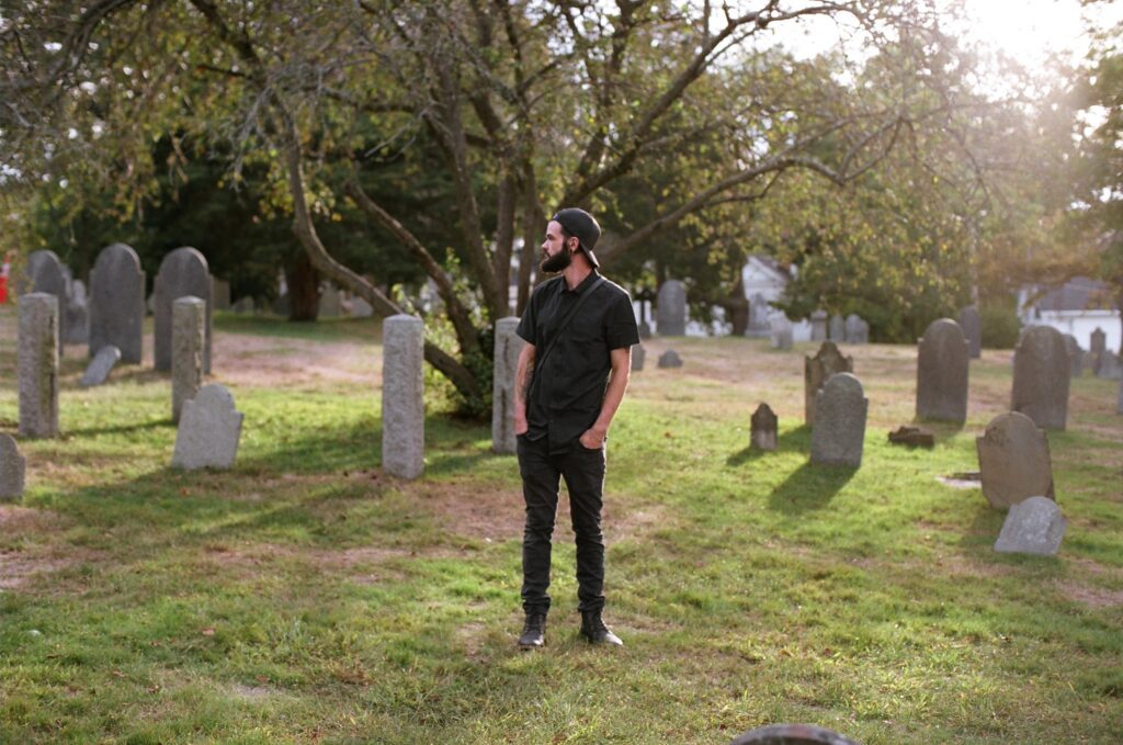 A man stands with his hands in his pockets.