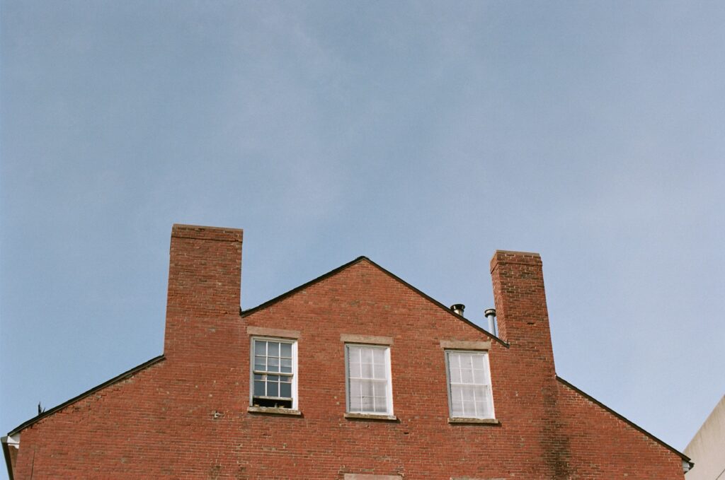 Clouds pass by a brick industrial building in Salem.