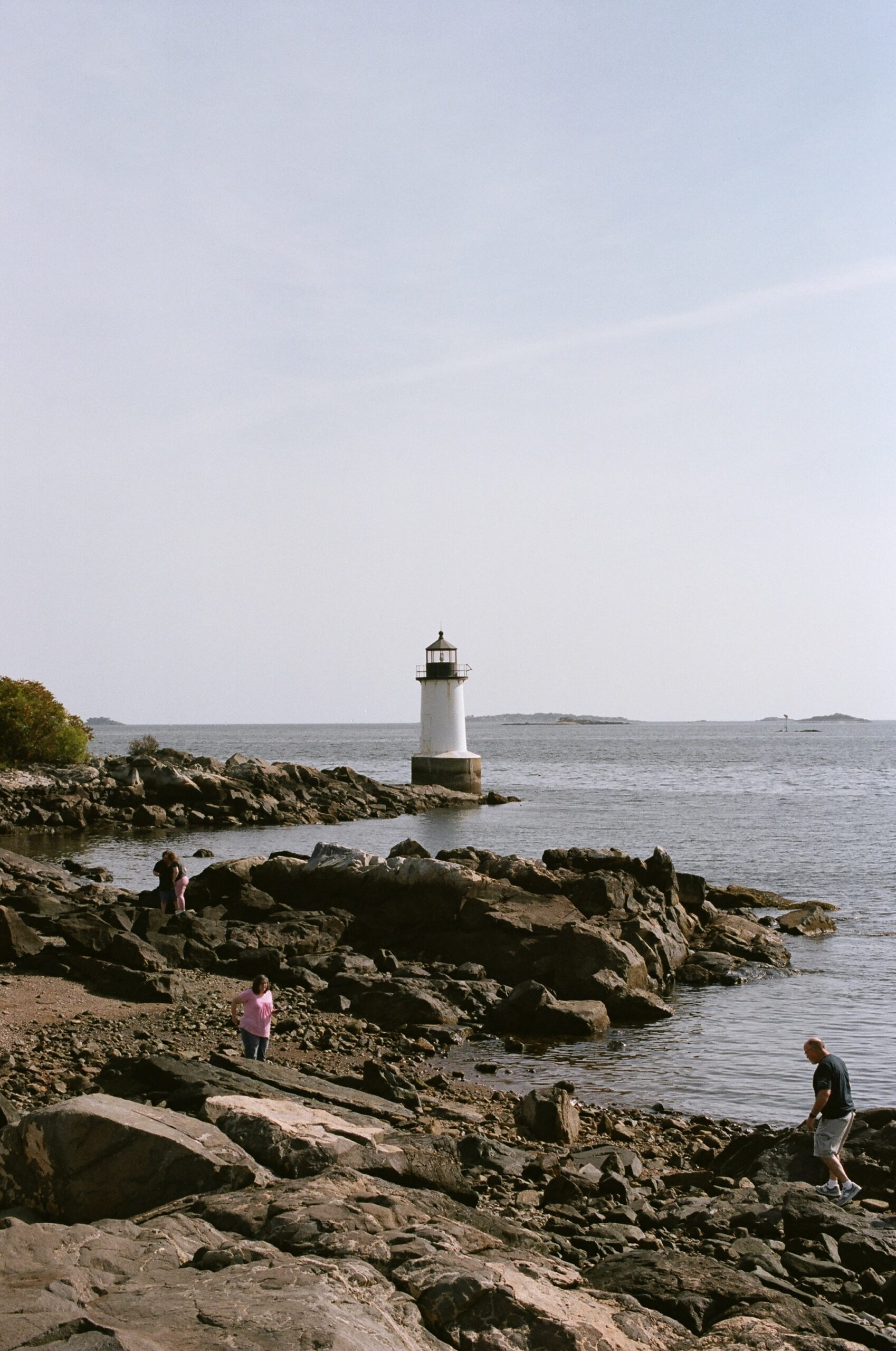A lighthouse sits on the coast of Salem in film photography.