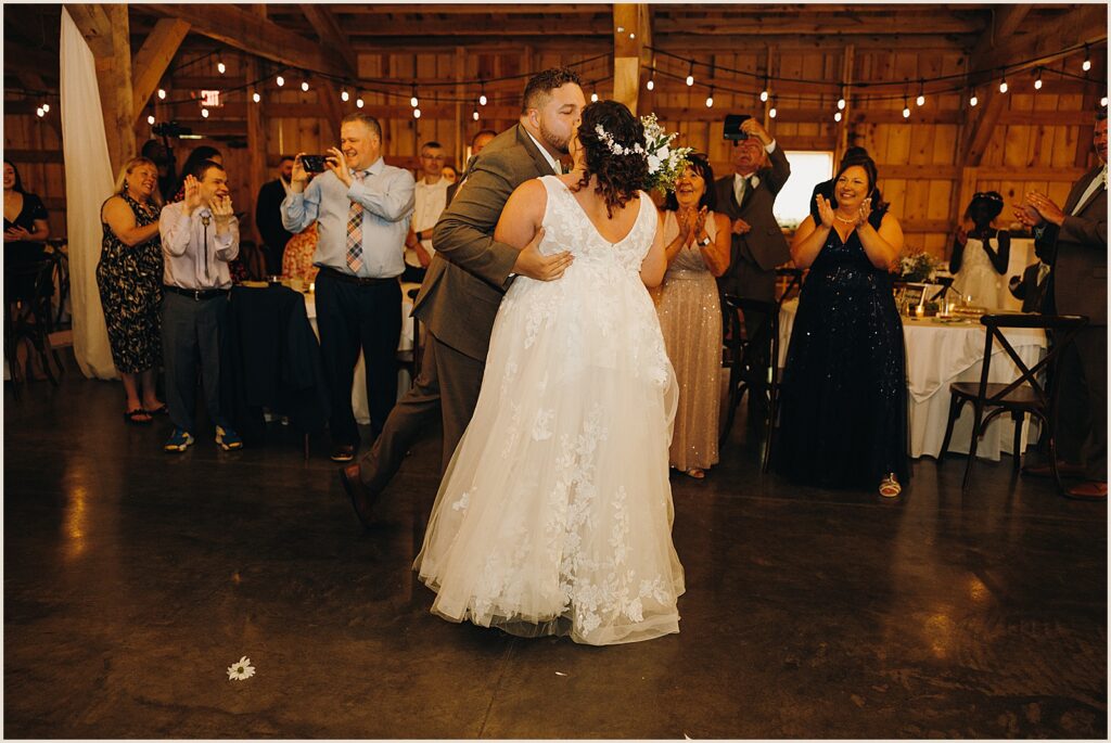 A bride and groom kiss during their first dance.