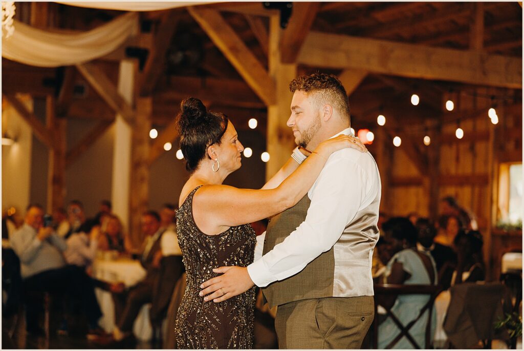 A groom dances with his mother.