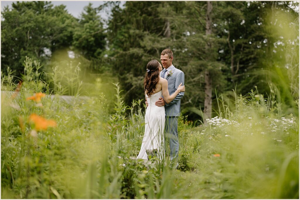 A bride and groom embrace in a garden outside the West Mountain Inn.