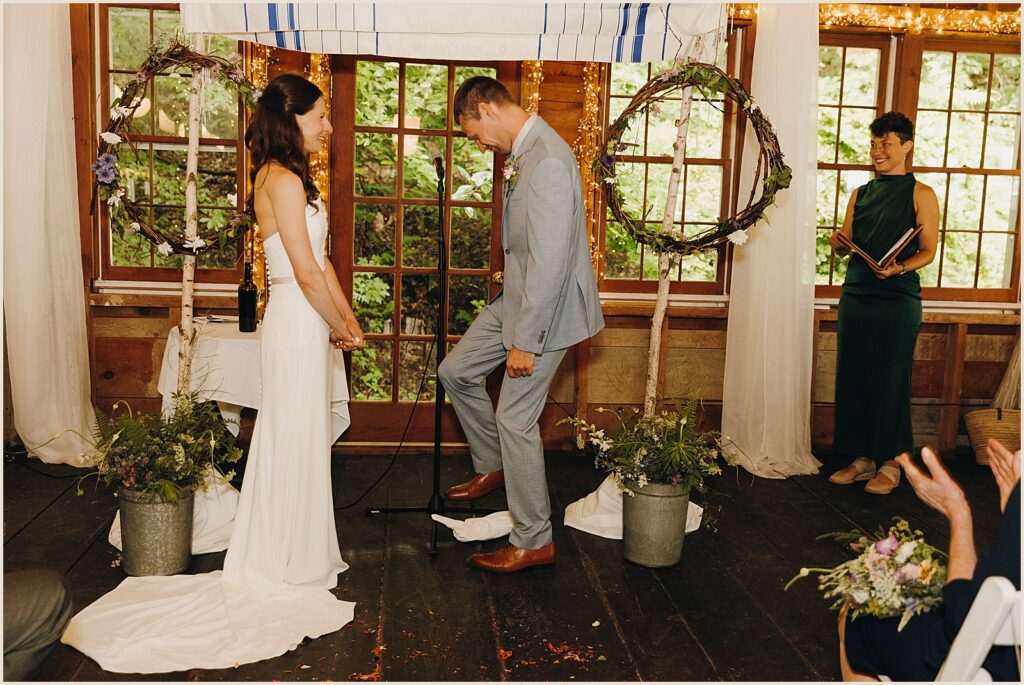A groom steps on a glass at the end of a Jewish wedding ceremony.