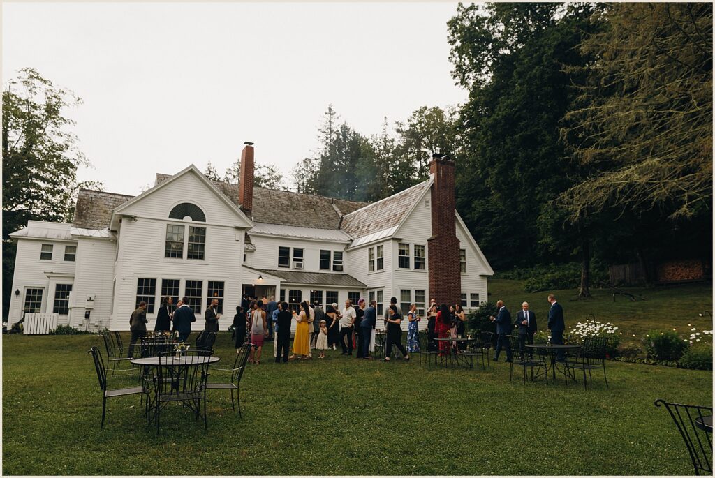 Wedding guests gather for cocktail hour on the porch at the West Mountain Inn.