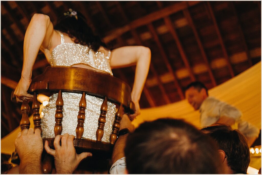 A bride holds onto a chair during the hora.