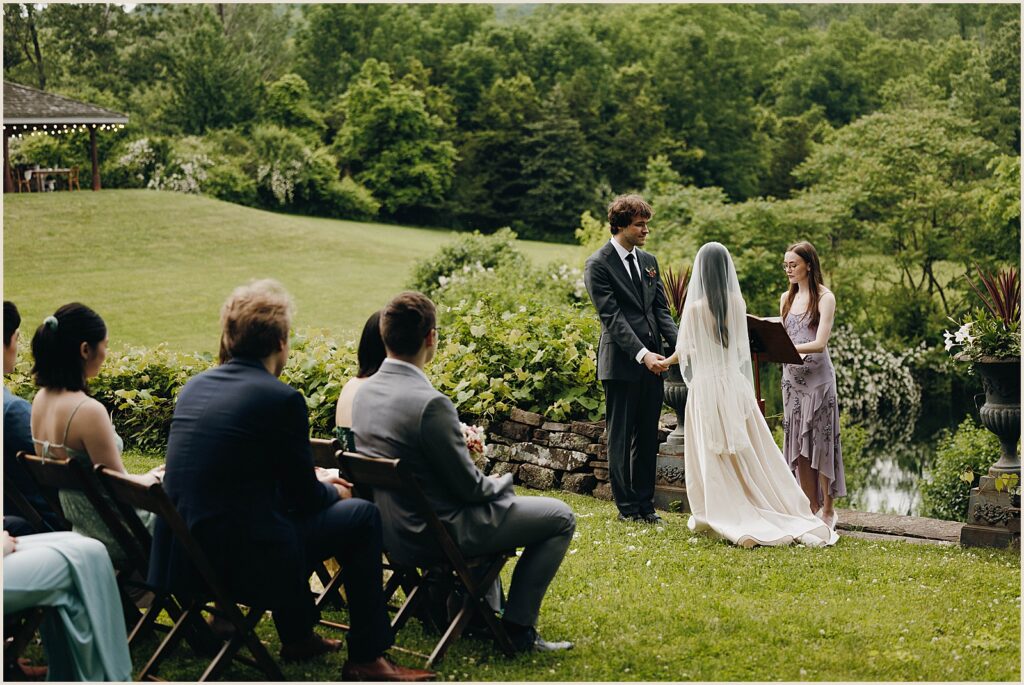 An officiant reads from a script during a wedding ceremony in the Catskills.