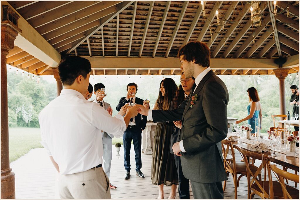 Wedding guests clink glasses in a toast.