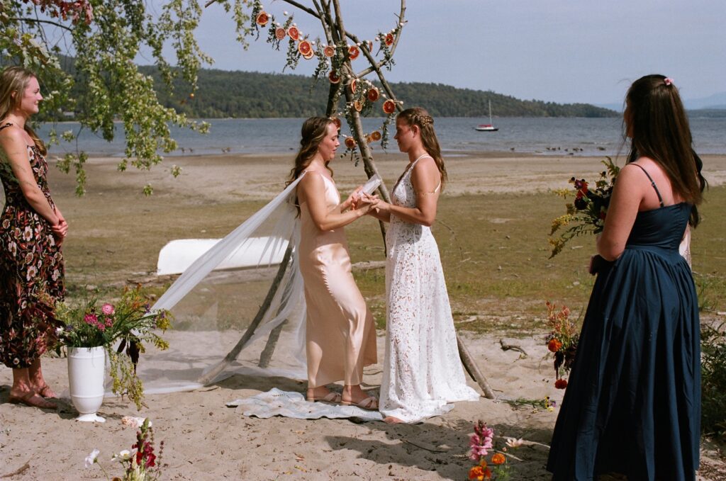 A couple stands before a handmade arch sharing wedding vows, a witchy wedding idea