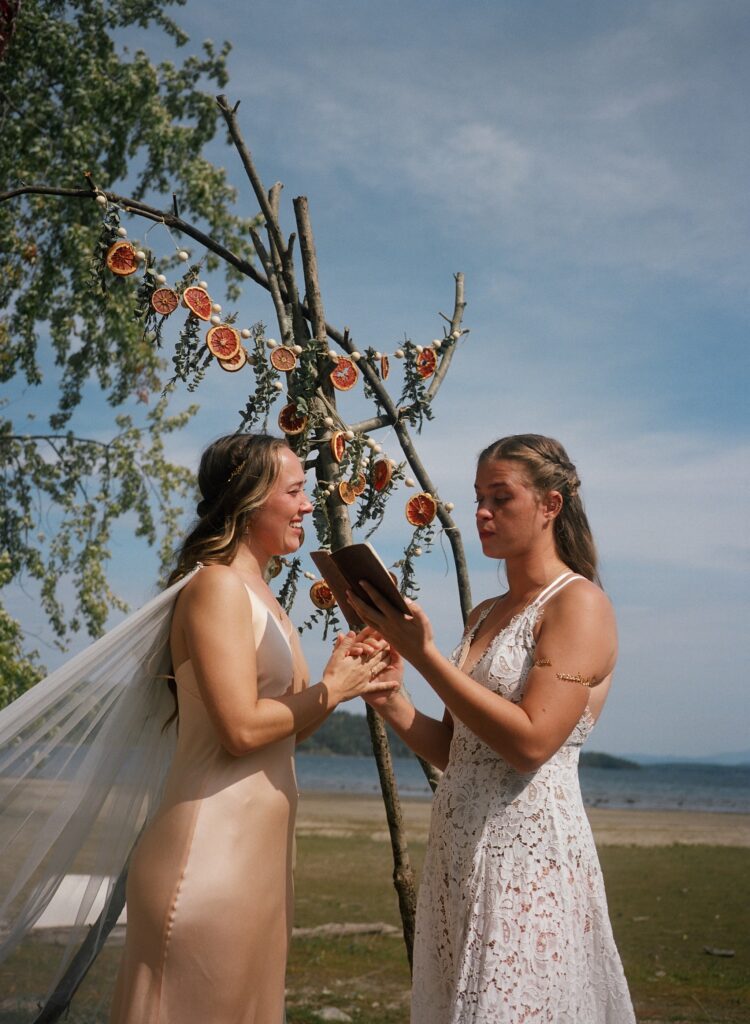 A couple holds hands during a intimate ceremony on the beach during an intentional wedding day