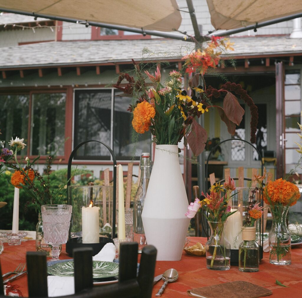 A table scape with seasonal flowers and lanterns. touches of a witchy wedding 