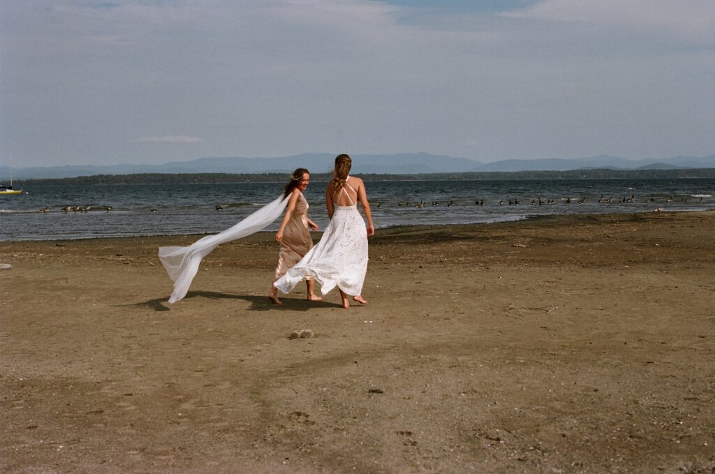 Bride a flowing cape as part of a symbolic, intentional wedding day walks down the beach